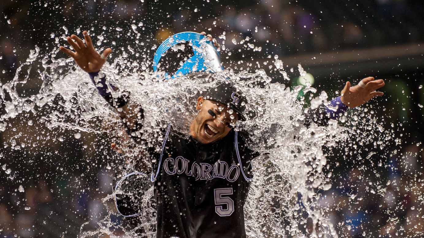 Carlos Gonzalez is drenched by one of his Colorado teammates after hitting a walk-off home run against the Los Angeles Dodgers on Saturday, September 26.