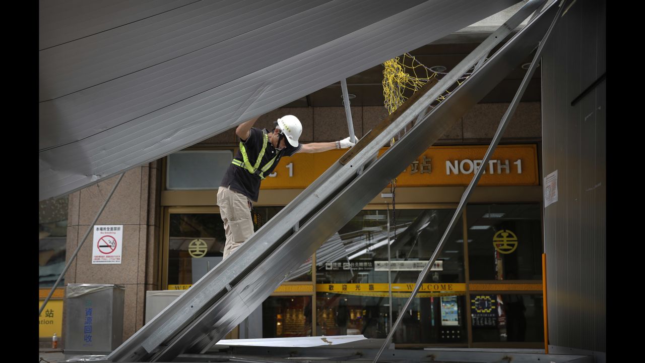A construction crew member removes fallen scaffolding at a train station in Taipei on September 29.