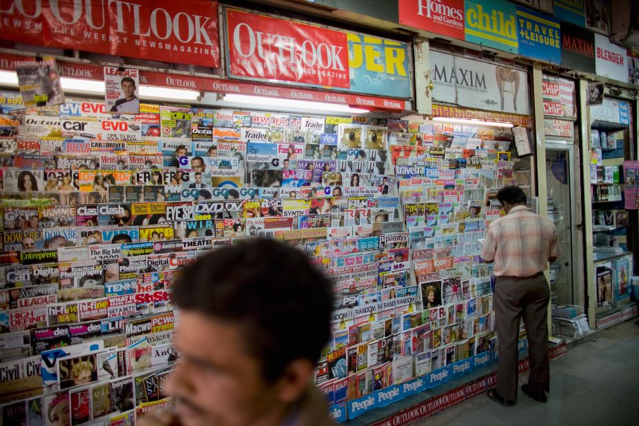 A customer looks at magazines at a newstand in Khan Market in New Delhi, India. 