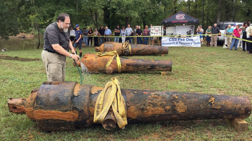 In this photo provided by the University of South Carolina, University of South Carolina archaeologist and state archaeologist Jon Leader washes and inspects one of the three Civil War cannons pulled from the Pee Dee River on Tuesday, Sept. 29, 2015, in Mars Bluff, S.C. The three cannons were dumped in the river by Confederate forces from the gunboat CSS Pee Dee in 1865 in order to keep them from falling into the hands of Union forces. (Margaret "Peggy" Ryan Binette/University of South Carolina via AP)