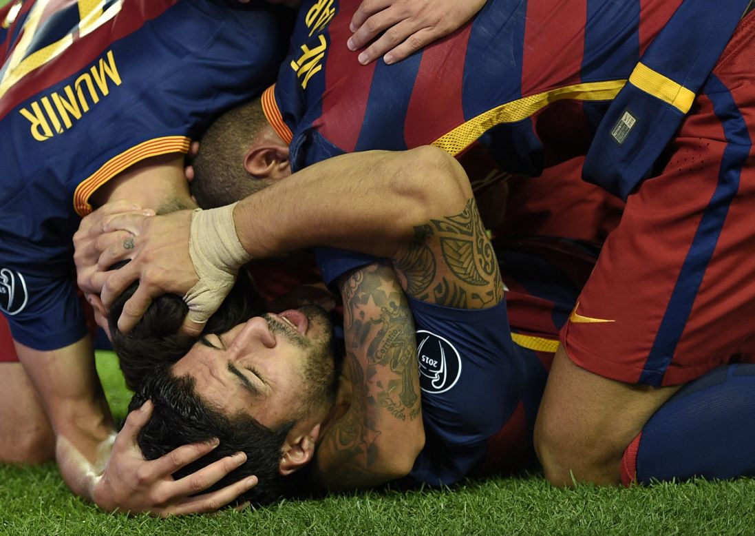 Luis Suarez is mobbed by his  relieved Barcelona teammates after scoring a late winner against German side Bayer Leverkusen at the Camp Nou on Tuesday.  