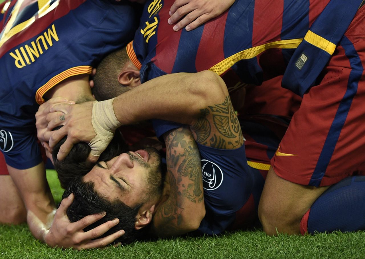 Luis Suarez is mobbed by his  relieved Barcelona teammates after scoring a late winner against German side Bayer Leverkusen at the Camp Nou on Tuesday.  
