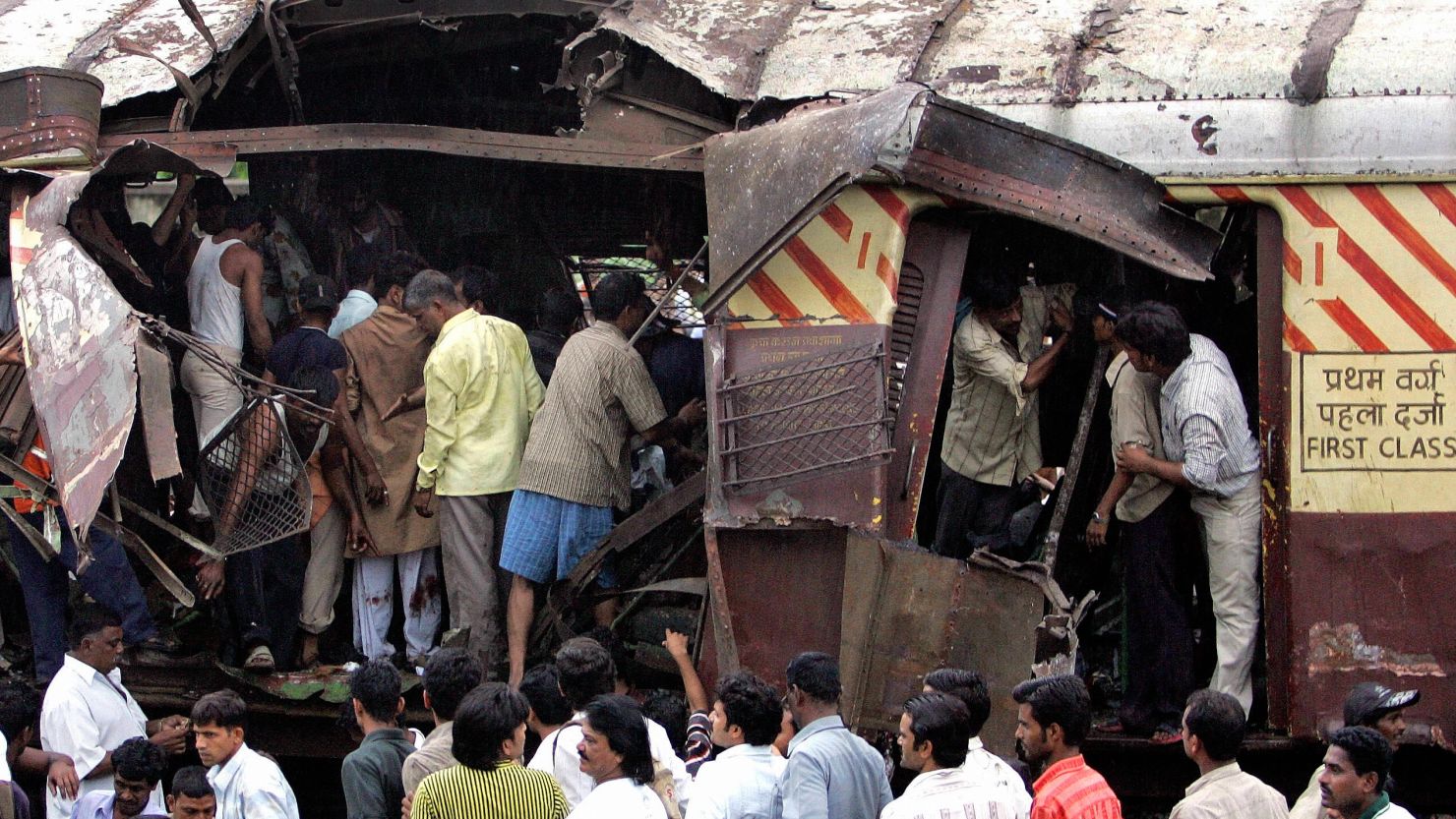 Rescue workers search for bodies inside the mangled compartment of a train after the 2006 bombing.