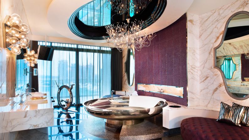 Guests at W Singapore Sentosa's Extreme Wow Suite don't have to choose between those two hotel necessities: a circular bath under a striking chandelier or a designer exercise bike.