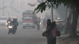 Motorists and pedestrians fight through a blanket of air pollution from agricultural and forest fires in Palembang, Sumatra, Indonesia.