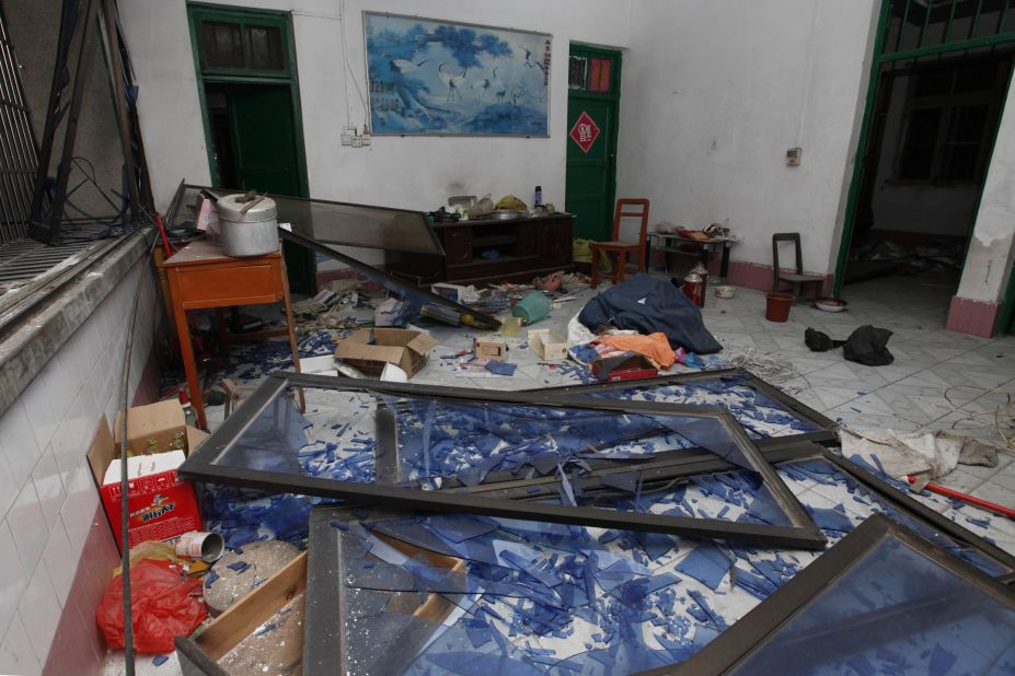 Damaged windows, debris and shattered glass are seen in a room that was hit by the explosion. 