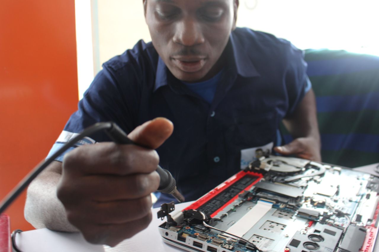 A SuperGeeks employees busy at work on one of the 200 devices the company repairs monthly.
