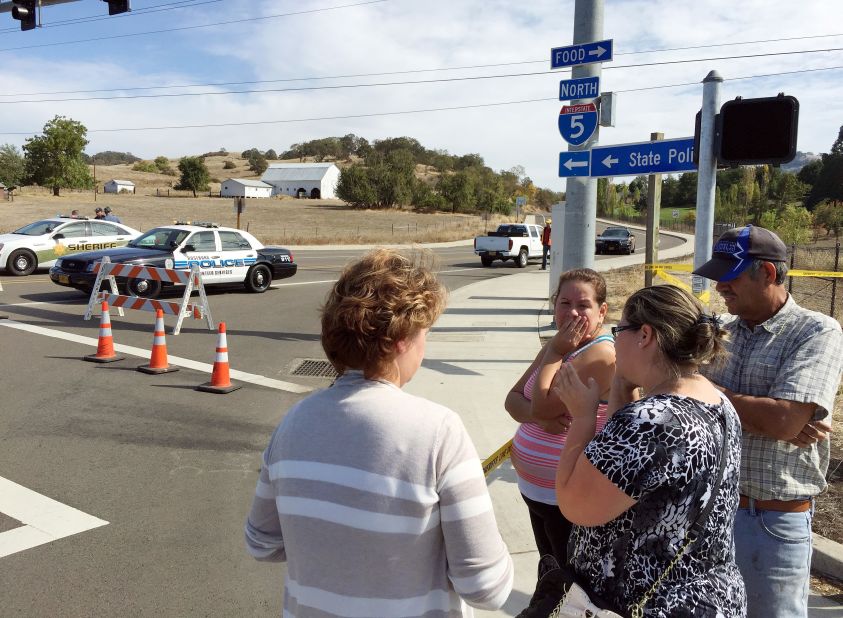 People gather at a roadblock near the entrance to the college on October 1.