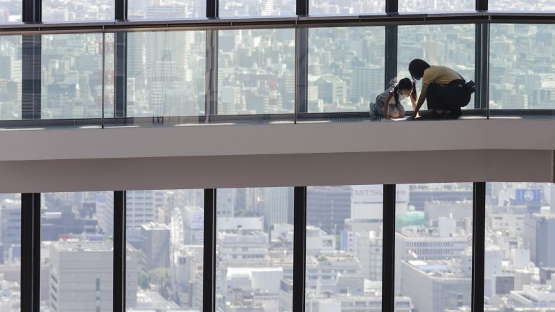 A woman and child examine a map on the Sky Promenade at Midland Square, a skyscraper in Nagoya, Japan, on Monday, September 28.