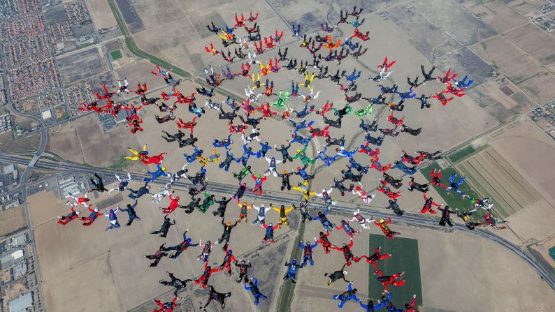 Skydivers link together above Perris, California, on Tuesday, September 9. They set a world record for largest sequential skydiving formation (202 skydivers).