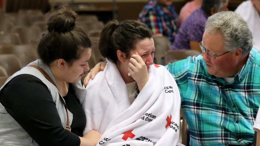Hannah Miles, center, is reunited with her sister Hailey Miles, left, and father Gary Miles, right, after a shooting at Umpqua Community College in Roseburg, Ore., on Thursday, Oct. 1, 2015.   (AP Photo/Ryan Kang)