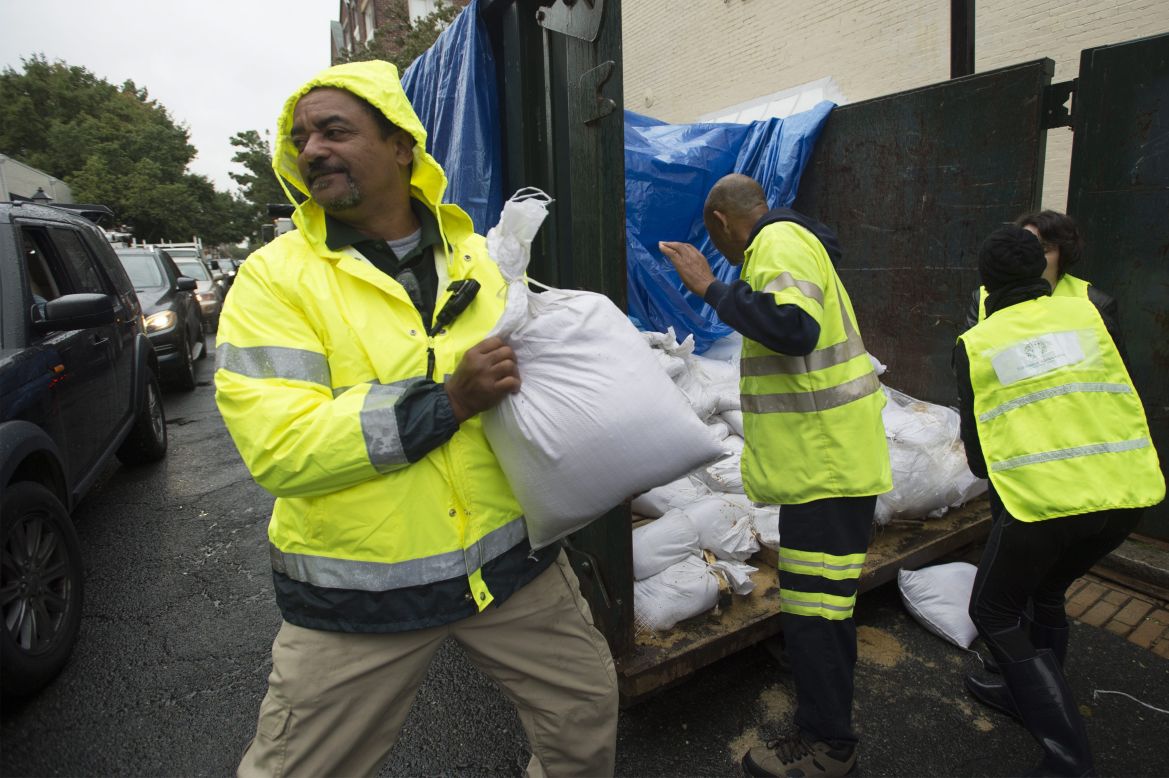 Volunteers and public works employees load sandbags into people's cars on Friday, October 2, as residents of Alexandria, Virginia, prepare for potential flooding.