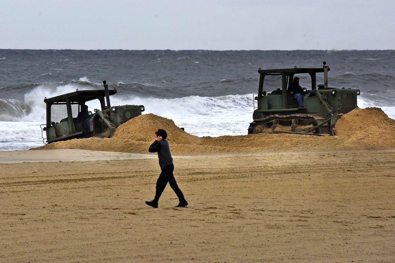 A boy walks on a beach in Belmar, New Jersey, on October 1, as front loaders build sand dunes in preparation for Hurricane Joaquin. 