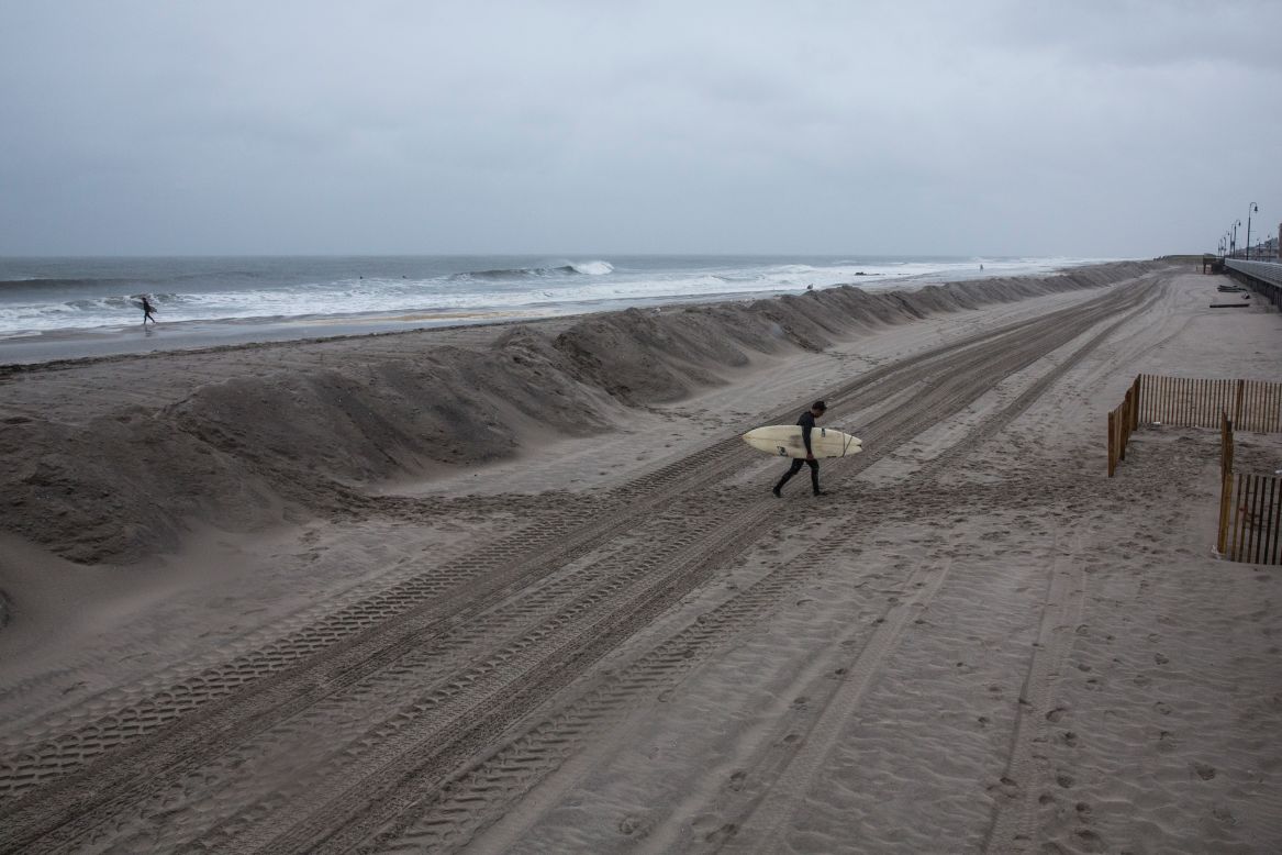 Darren Gallo walks home in Long Beach, New York, after two hours of surfing on October 2. The storm might stay in the Atlantic Ocean, away from the U.S. East Coast, but there is still a concern about heavy rain and potential flooding.