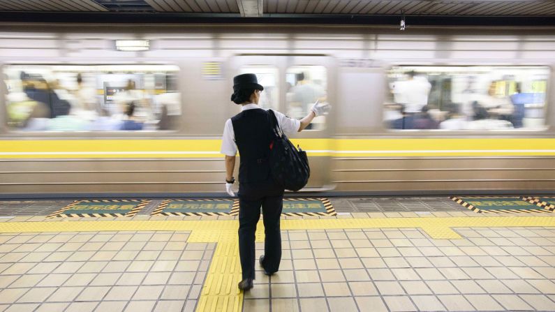 A train conductor signals a clear subway platform to a colleague. Nagoya is home to the SCMaglev and Railway Park, a railway museum where train lovers can get a hands-on look at the impressive collection.