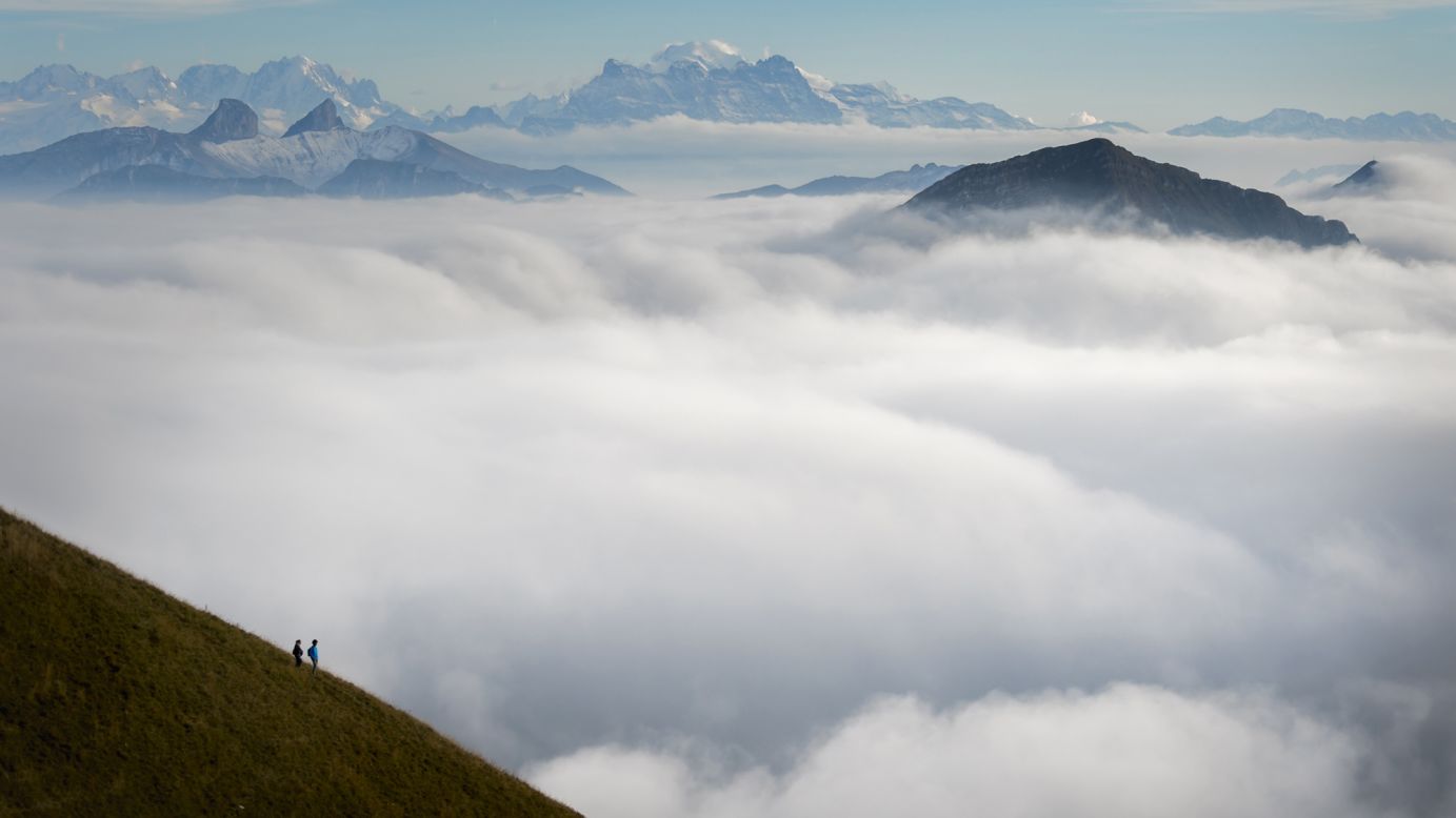 Tourists stand on top of Moleson Mountain in western Switzerland, looking over a sea of mist. The weather phenomenon is known in German as "nebelmeer."