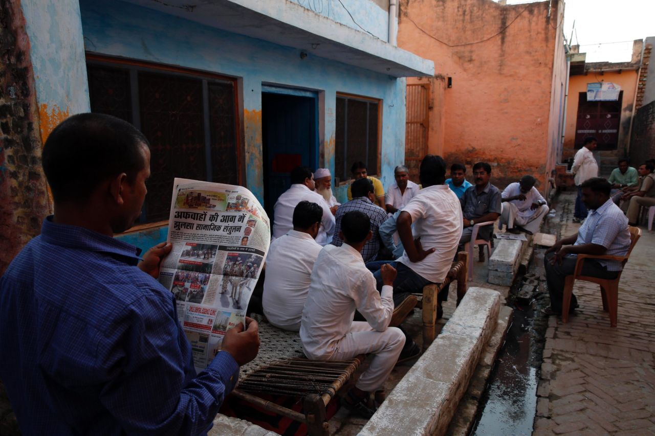 A relative of Mohammad Akhlaq reads about the killing in a newspaper in Bisara on September 30.