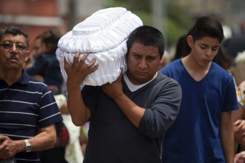 Welsar Nazario carries the coffin of his 5-month-old nephew Alezandro Macario, who died in a mudslide, to the Santa Catarina Pinula cemetery on the outskirts of Guatemala City on October 3. 