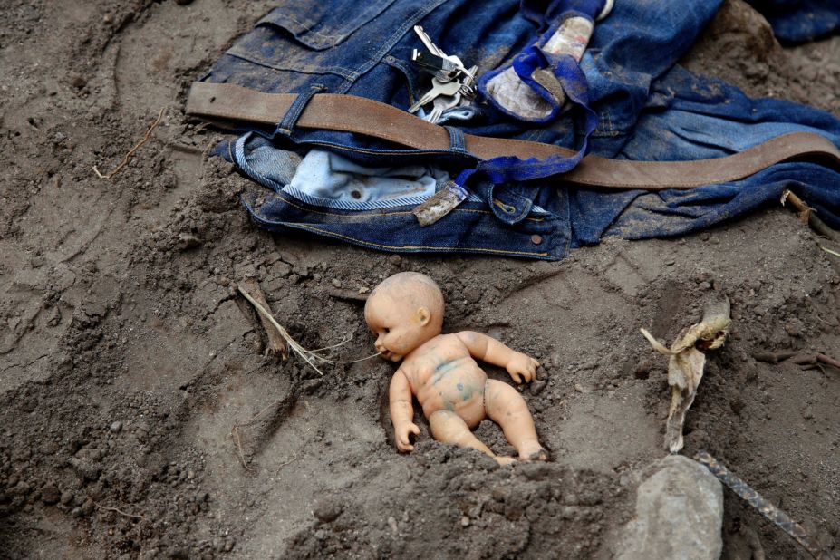 A doll and clothing lie in the mud as rescue workers continue to search the site of a mudslide on October 3. 