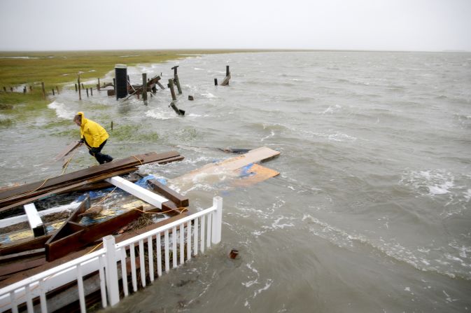 Stuart Tait ties together wood after his house collapsed into an inlet  on Grassy Sound during high tide on October 3 north of North Wildwood, New Jersey. 
