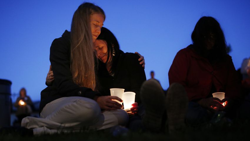 Heidi Wickersham, left, embraces her sister Gwendoline Wickersham during a vigil on Saturday, October 3, in Winston, Oregon.