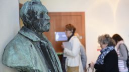Journalists walk past a bust of Alfred Nobel as they arrive to attend a press conference of the Nobel Committee to announce the winner of the 2015 Nobel Medicine Prize on October 5, 2015 at the Karolinska Institutet in Stockholm, Sweden.    AFP PHOTO / JONATHAN NACKSTRAND        (Photo credit should read JONATHAN NACKSTRAND/AFP/Getty Images)