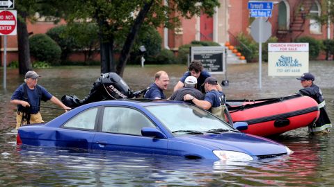 Members of Norfolk Fire-Rescue pull a man from his car in Norfolk, Virginia, on Sunday, October 4.