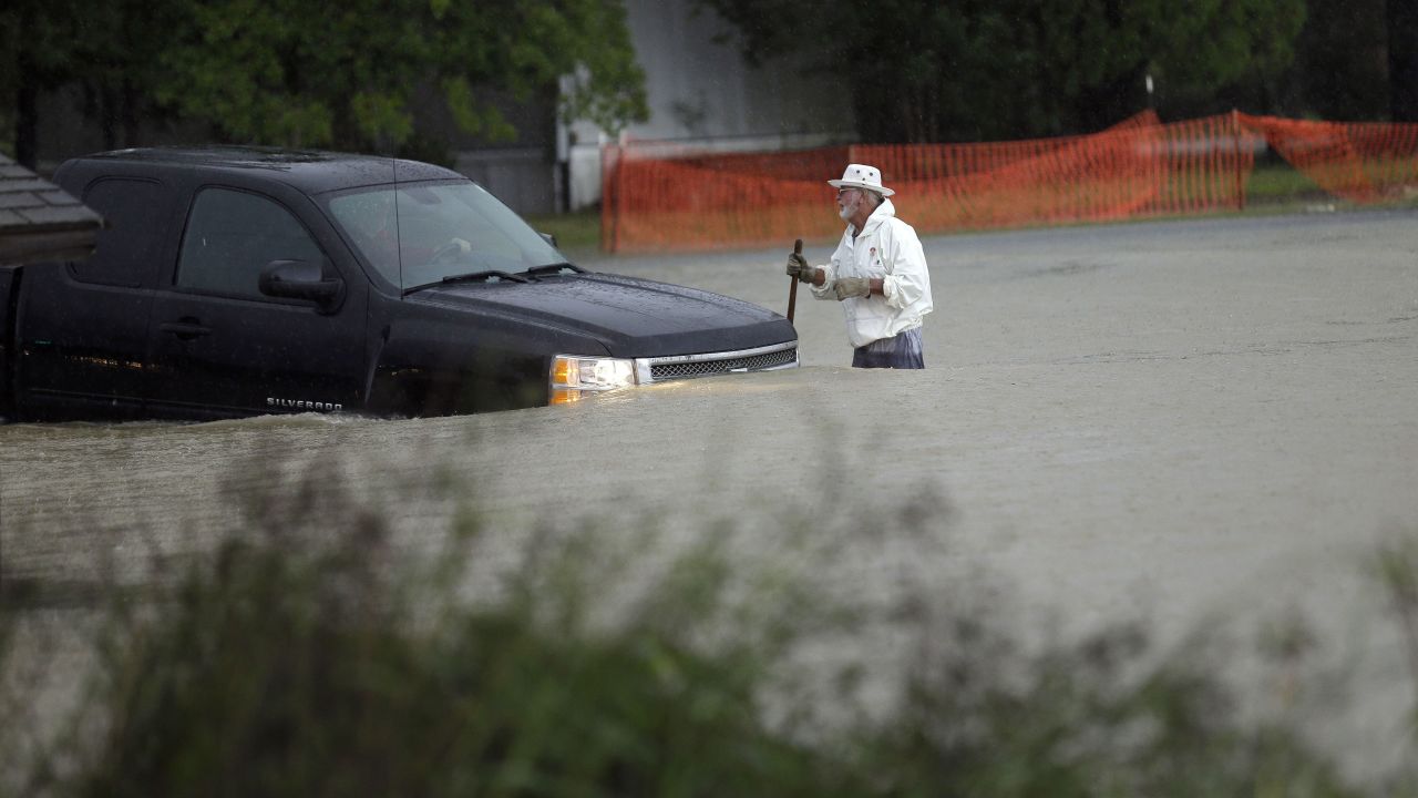 A man watches as a vehicle tries to navigate flood waters in Florence, South Carolina, on October 4.