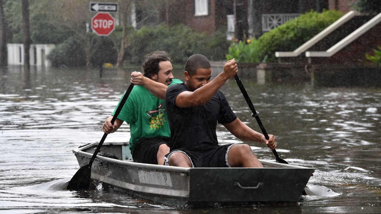 Two men row a boat on a flooded street in downtown Charleston, South Carolina, on October 4.