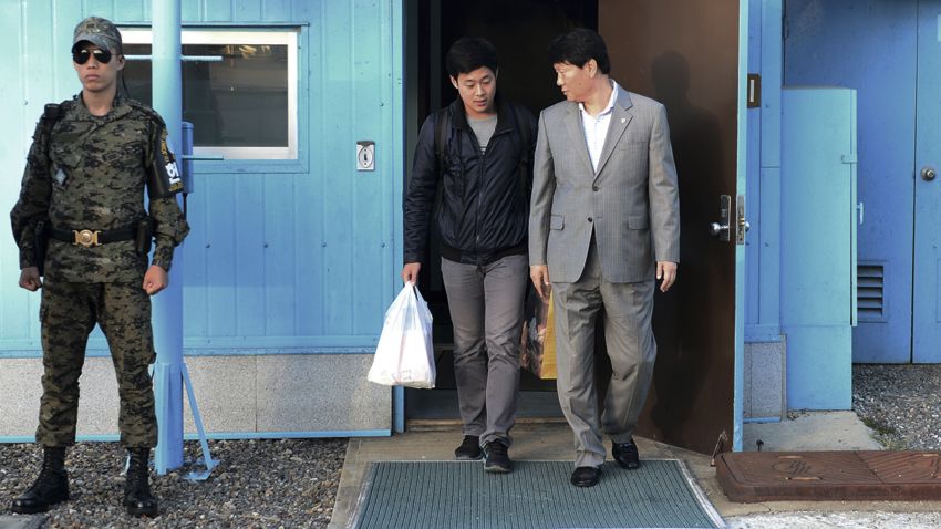 In this photo provided by the South Korean Unification Ministry, South Korean Won Moon Joo, center, who has a permanent resident status in the United States, is escorted by a South Korean official at the border village of Panmunjom in Paju, South Korea, Monday, Oct. 5, 2015. North Korea freed a South Korean national who'd been attending New York University before his detention, Seoul officials said Monday, in a possible sign Pyongyang wants better ties with rival Seoul and may back away from a recent threat to launch a long-range rocket later this month. (The South Korean Unification Ministry via AP)