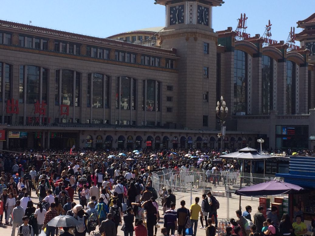 Crowds flow into Beijing's main railway station on October 2, 2015. China Railway Corporation said more than 100 million passengers are expected to travel by rail during the holiday.