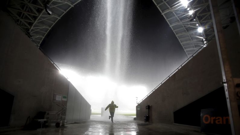 A man runs for cover after heavy rain stopped a soccer match in Nice, France, on Saturday, October 3. The Ligue 1 match between Nice and Nantes was suspended at halftime because the field was waterlogged.