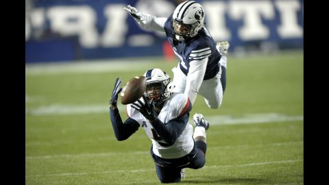 Connecticut's Noel Thomas tries to bring in a catch as he's defended by BYU's Micah Hannemann during a college football game Friday, October 2, in Provo, Utah.