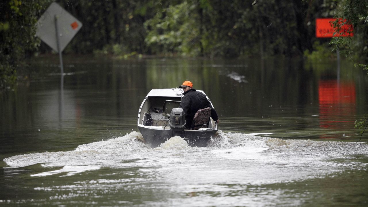 Hunter Baker drives his boat down a flooded East Black Creek Road to his home following heavy rains in Florence on October 5. 