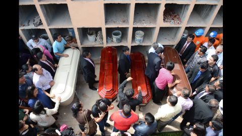 People in Santa Catarina Pinula surround the coffins of four landslide victims on Sunday, October 4.