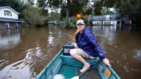 A woman uses her boat to check on neighbors and see if they want to evacuate in Summerville, South Carolina, on Monday, October 5.