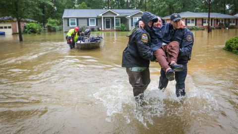 Police officers carry a woman to dry land after she was rescued from her home in the St. Andrews area of Columbia, South Carolina, on October 5.