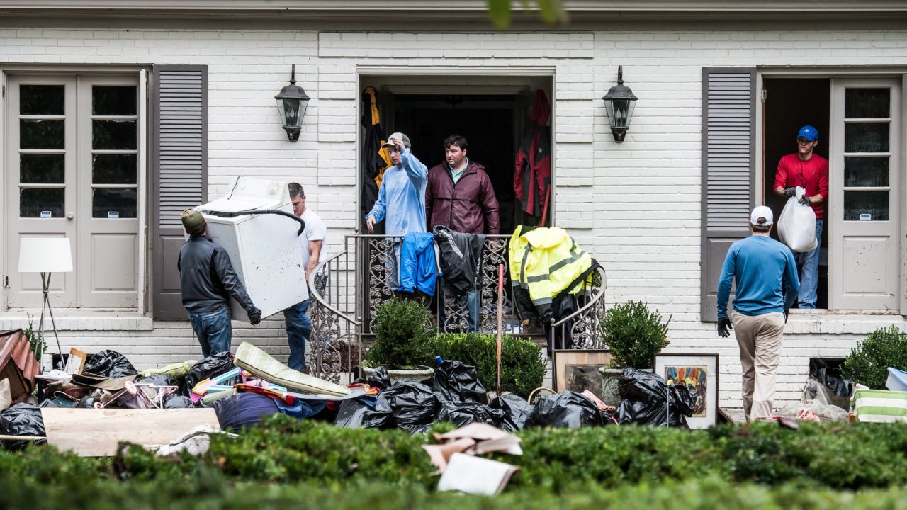 Neighbors and friends help clean up a home affected by flooding in Columbia on October 5.