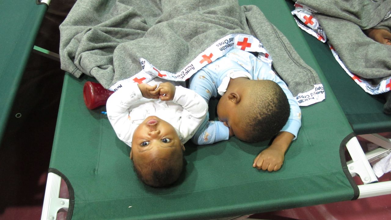 Five-month-old Jeremiah Odum, left, and his 2-year-old brother, Braxton Odum, nap on a cot in a high school gymnasium being used as a Red Cross shelter for flood evacuees in Rowesville, South Carolina, on October 5.