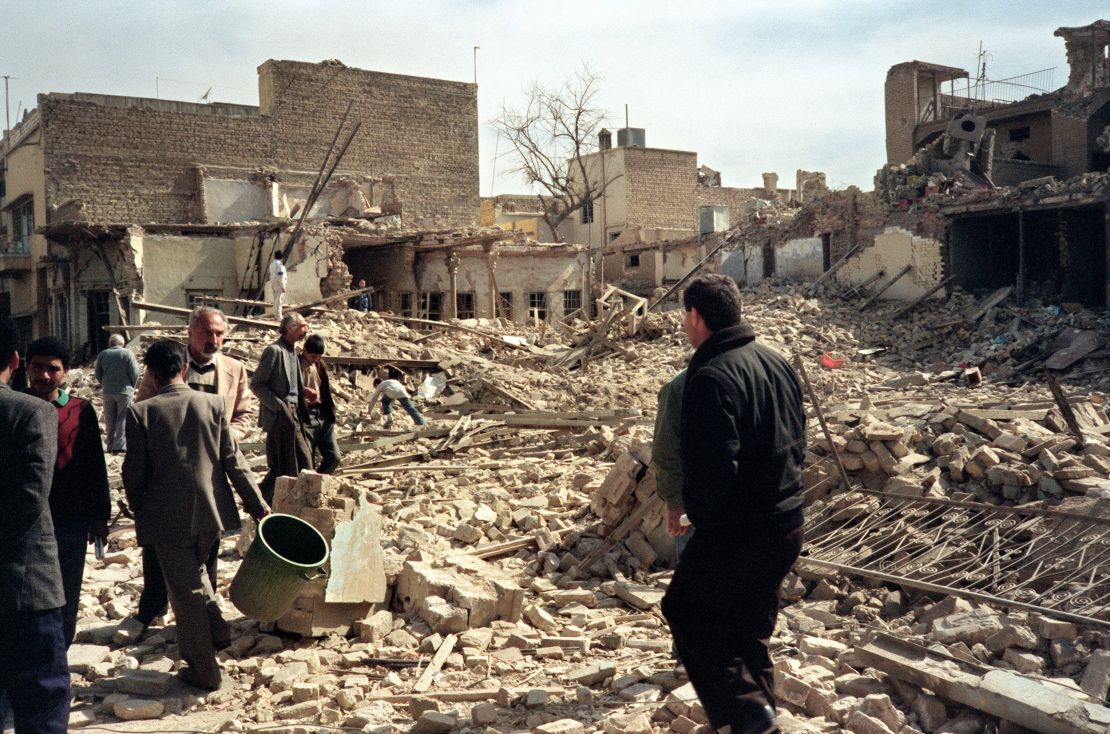 Iraqi civil defense workers and civilians look at destroyed houses after an allied bombing raid on a Baghdad street in February 1991. 