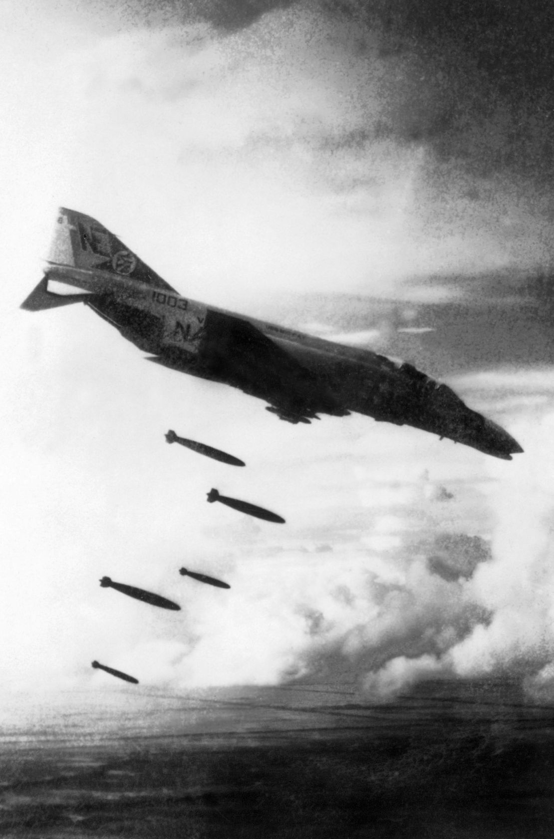 A U.S. F4 Phantom drops bombs over a Viet Cong controlled area in South Vietnam in November 1965 during the Vietnam War.