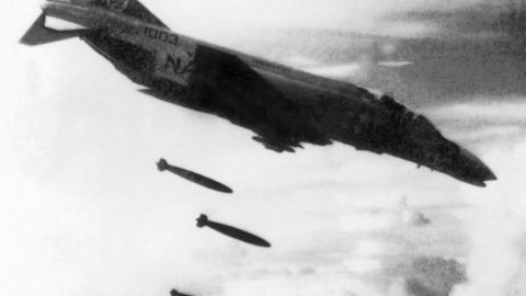 A U.S. F4 Phantom drops bombs over a Viet Cong controlled area in South Vietnam in November 1965 during the Vietnam War.