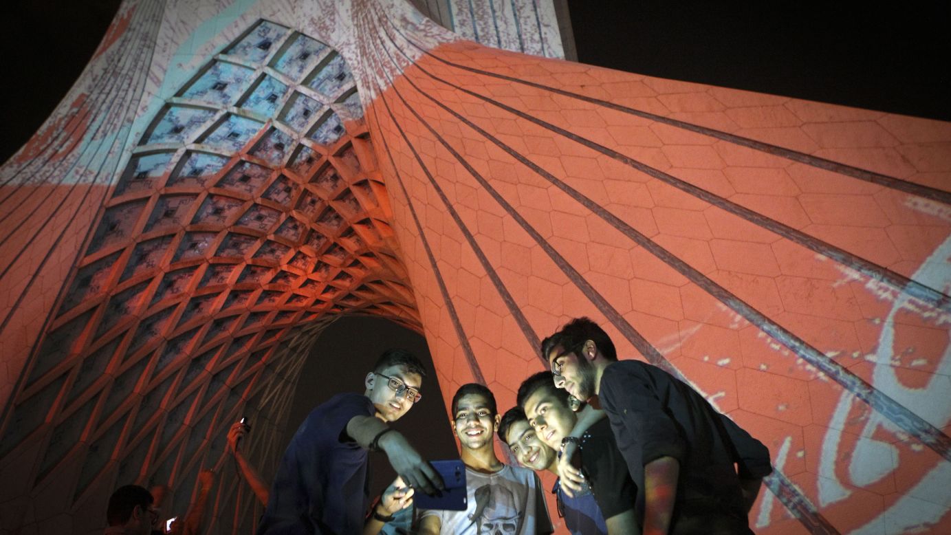 Boys take a selfie as they stand beside the Azadi Tower in Tehran, Iran, on Monday, October 5.