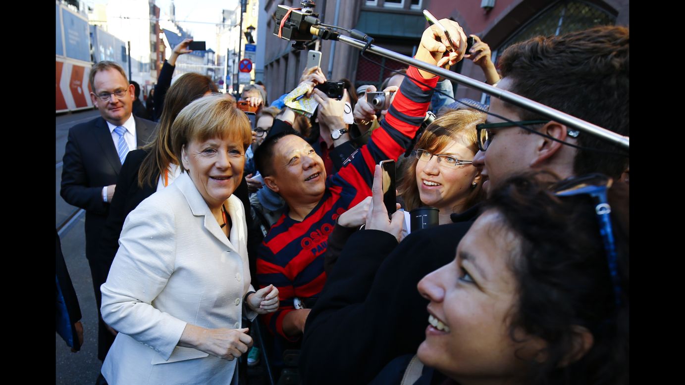 German Chancellor Angela Merkel poses for a selfie with a man in Frankfurt, Germany, on Saturday, October 3.