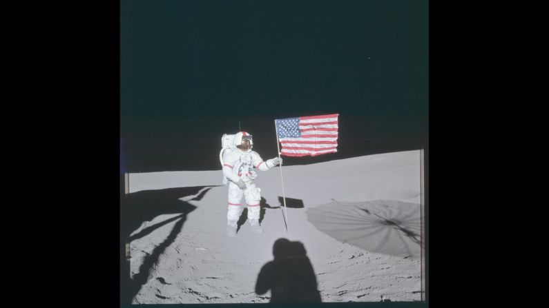 Apollo 14 commander Alan Shepard poses next to the American flag while walking on the moon's surface in February 1971.