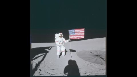 Apollo 14 commander Alan Shepard poses next to the American flag while walking on the moon's surface in February 1971.