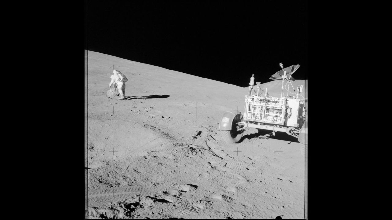 Scott studies a boulder on the moon during Apollo 15.