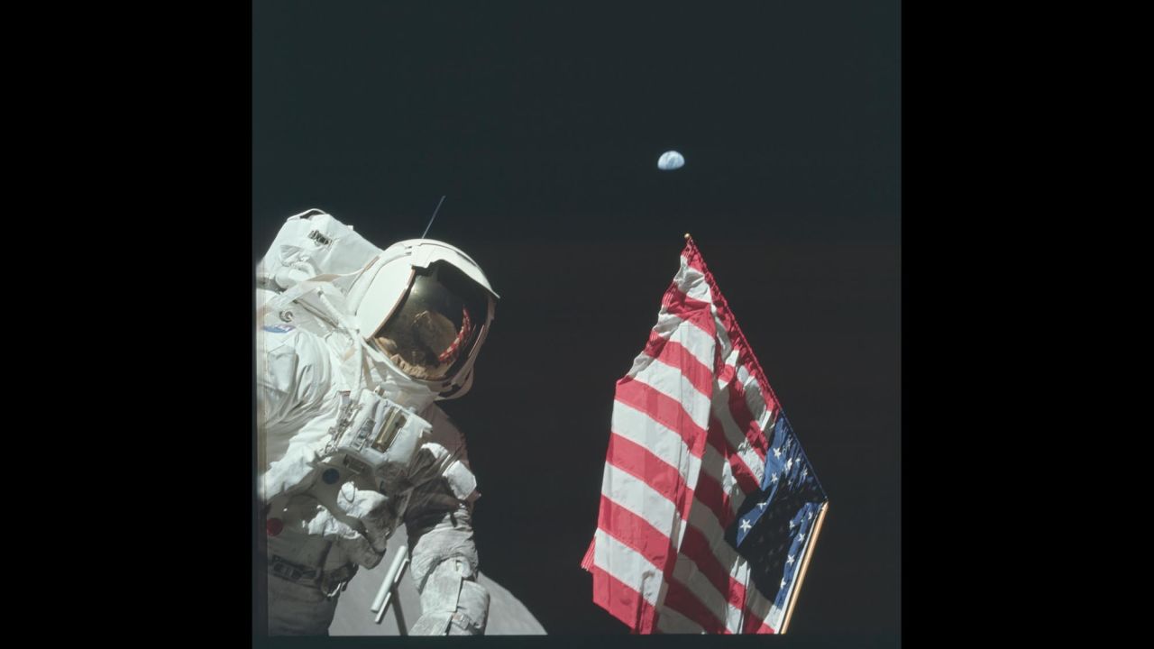 Astronaut Harrison Schmitt is photographed next to the American flag while walking on the moon during Apollo 17.