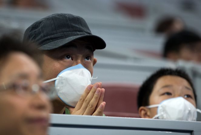 Mask-wearing spectators watch the first round women's singles match between Belinda Bencic of Switzerland and Madison Brengle of the United States on October 5.