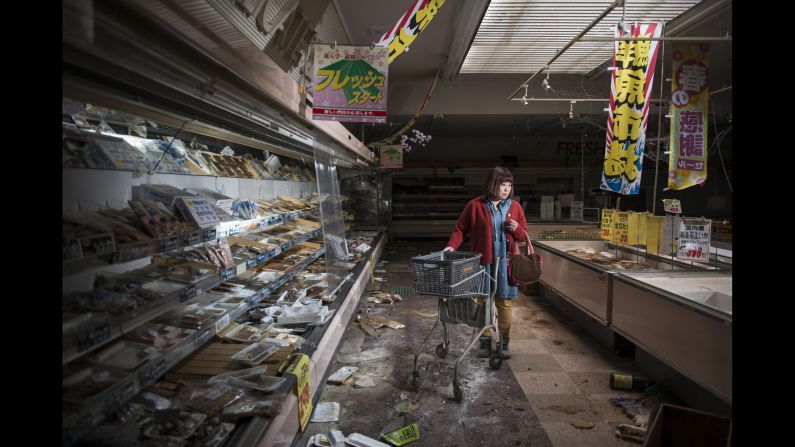 Following the 2011 Fukushima meltdown, photographers and documentarians Carlos Ayesta and Guillaume Bression made multiple trips to the no-go zone, photographing former residents of the region nearly five years later. Here, Midori Ito is staged in an abandoned supermarket in the prohibited city of Namie. Just after the disaster, Midori Ito evacuated to Minami Aizu for fear of health risks associated with radioactivity. 